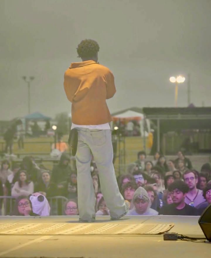 May be an image of standing, microphone, crowd, concert and text