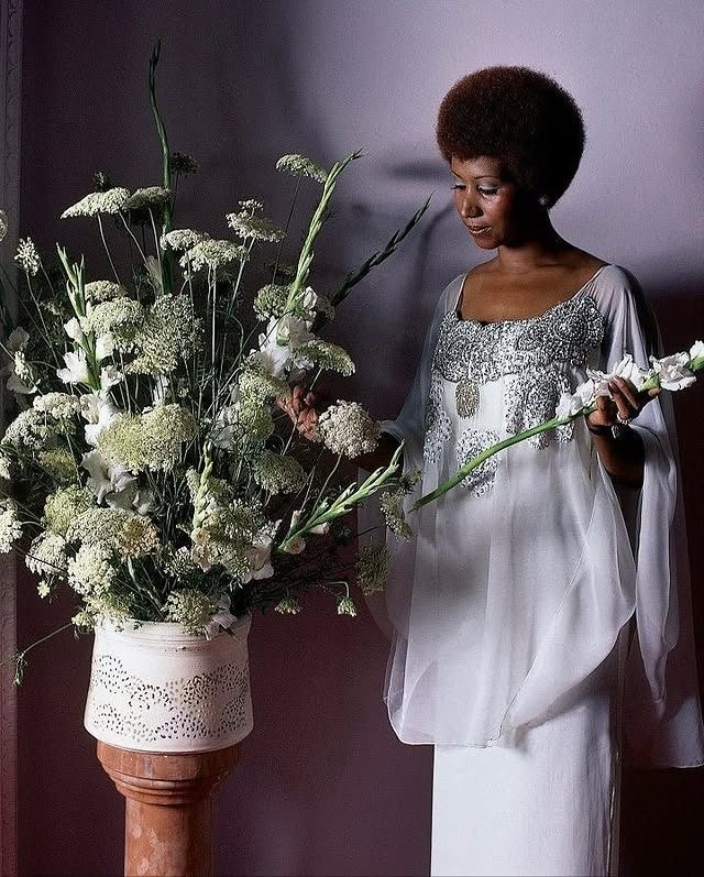 May be an image of flower arrangement, urn, baby's-breath and text