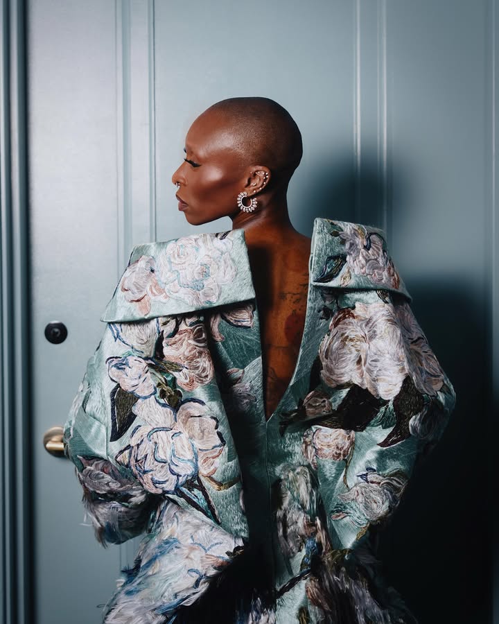 May be an image of one or more people, makeup, overcoat, jacket, raincoat and text