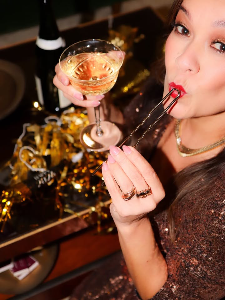 May be an image of champagne, wine glass, tinsel and text