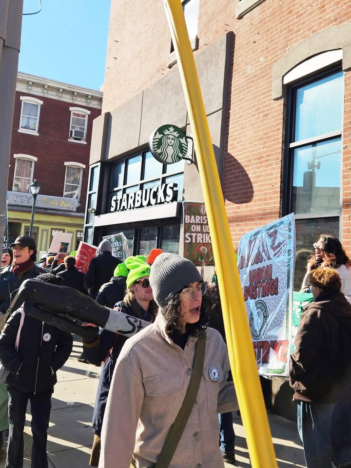 May be an image of standing, banner and text that says 'STARBUCKS L 1 BARIS ONU UL STRIK'