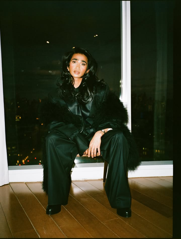 May be an image of one or more people, makeup, fur coat, goosedown coat, overcoat, turtleneck and text