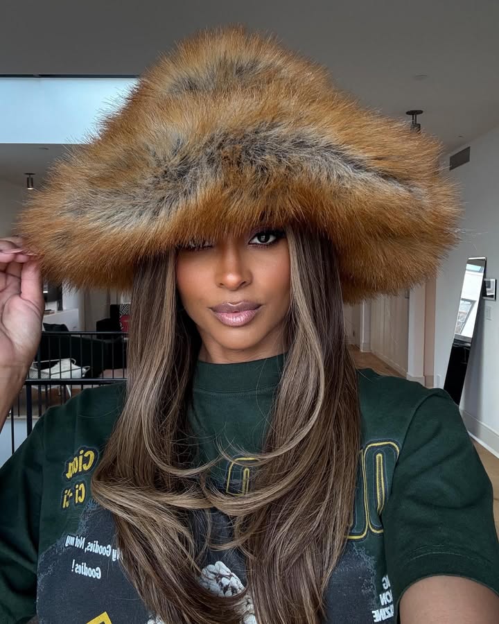 May be an image of one or more people, makeup, hair, fur coat, hat, beret and text