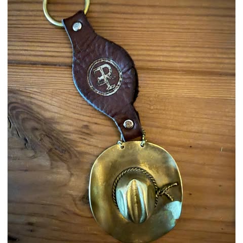 May be an image of saddle-stitched leather, brass, leather, padlock, key, belt buckle and text