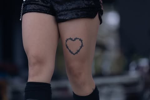 May be an image of one or more people, tattoo, heart, miniskirt, shorts and text