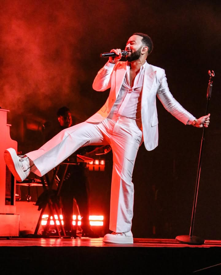 May be an image of dinner jacket, microphone, blazer, concert and text