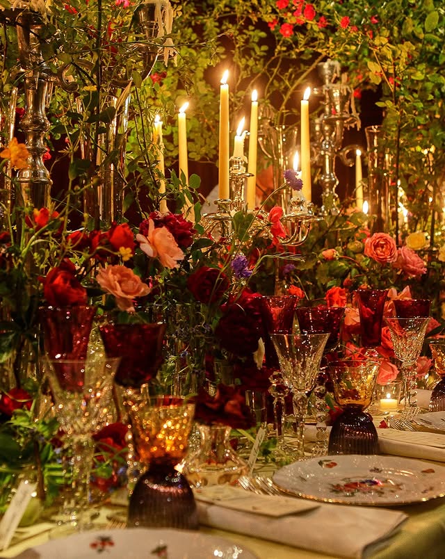 May be an image of candle holder, flower arrangement, candle, tablecloth, chandelier and text