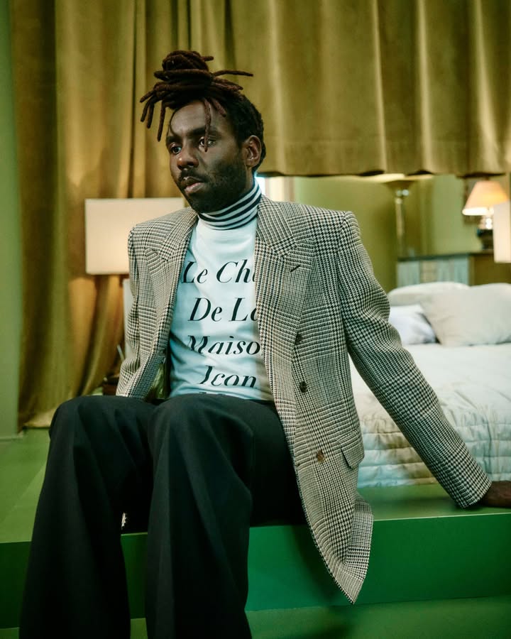 May be an image of overcoat, suit, turtleneck, blazer and text