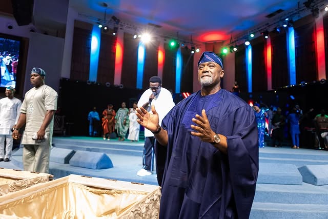 May be an image of one or more people, lighting, microphone, dais and text