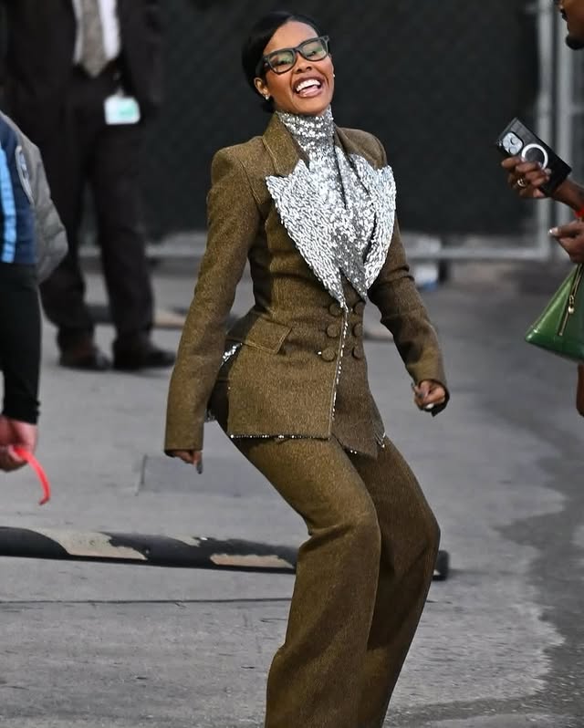 May be an image of one or more people, coat, suit, blazer and text