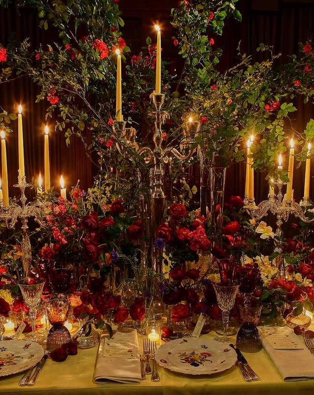 May be an image of candle holder, pomegranate, tablecloth, candle and text