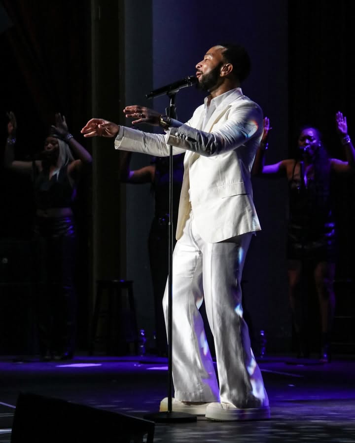 May be an image of dinner jacket, microphone, concert and text