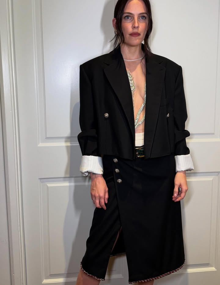 May be an image of suit, overcoat, blazer, kilt and text