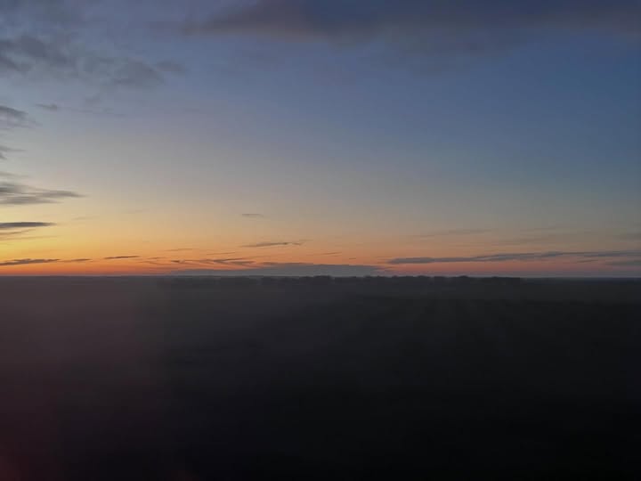 May be an image of horizon, twilight, fog, sky and text