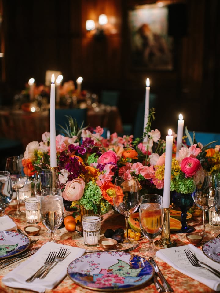 May be an image of candle holder, table, flower arrangement, tablecloth and text