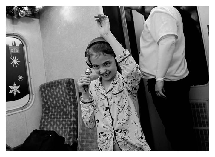 May be a black-and-white image of child, train, turnstile, portable cassette player and text