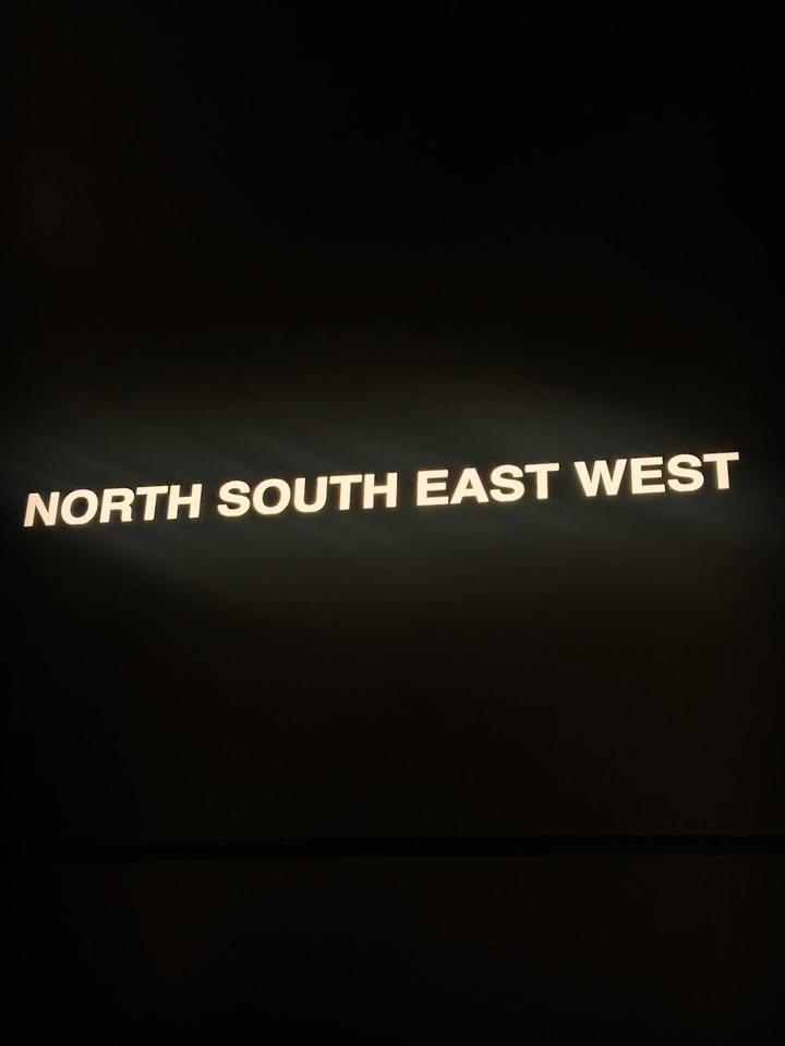 May be an image of signboard, night and text that says 'NORTH SOUTH EAST NORTHSOUTHEASTWEST WEST'