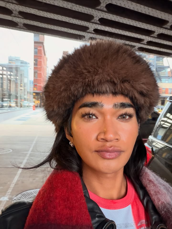 May be an image of one or more people, makeup, hat, sable coat, beret, headscarf, turtleneck and text