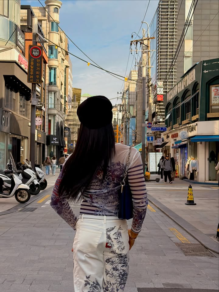 May be an image of headscarf, beret and street