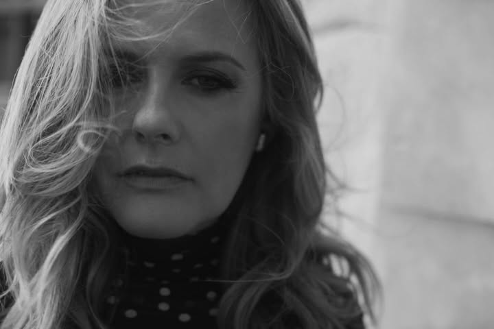 May be a black-and-white image of one or more people, blonde hair, makeup, people smiling, turtleneck and text