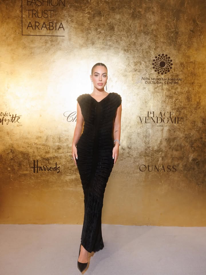 May be an image of one or more people, gown, carpet, dress and text