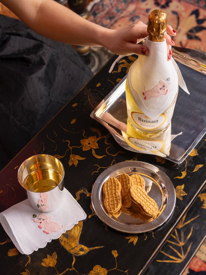 May be an image of champagne, tablecloth, placemat, wafer, napkin, carafe and text