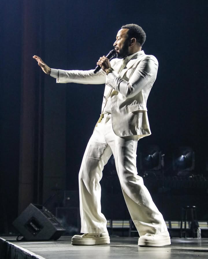 May be an image of blazer, microphone, concert and text