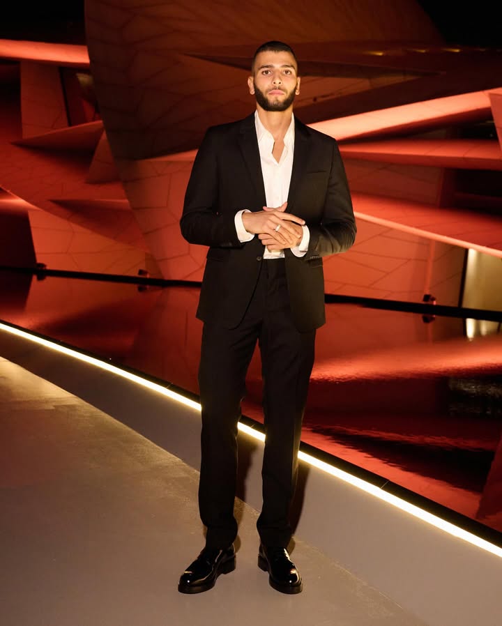 May be an image of suit, dinner jacket, blazer and text