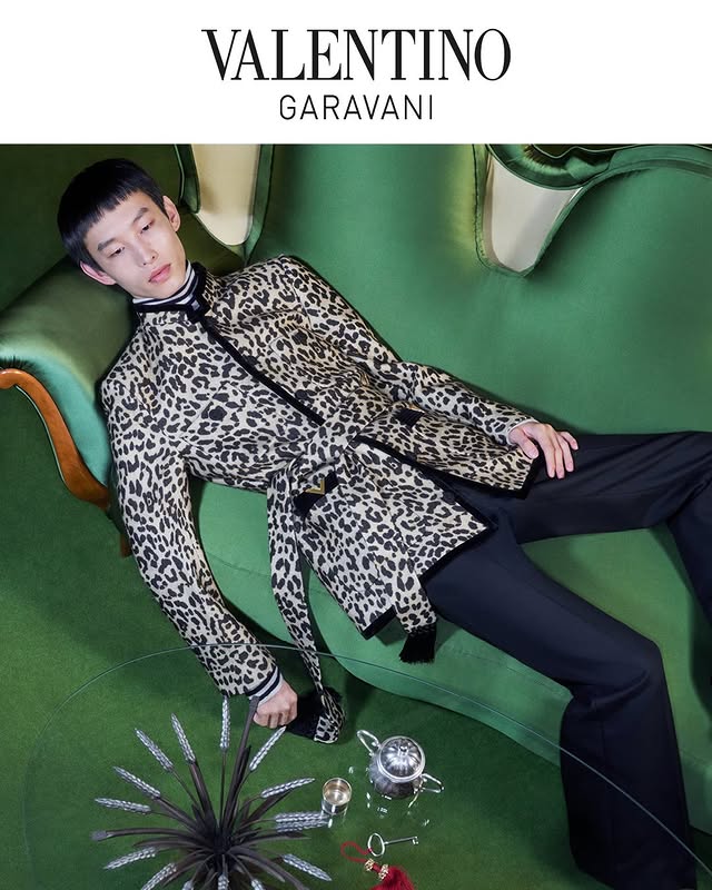 May be an image of one or more people, makeup, overcoat, suit, magazine, dinner jacket and text