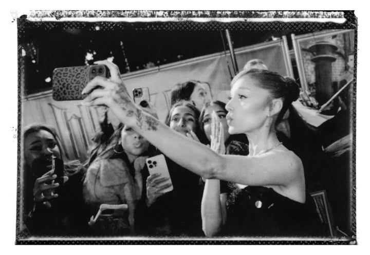 May be a black-and-white image of one or more people, blonde hair, makeup, polaroid, phone, camera and text