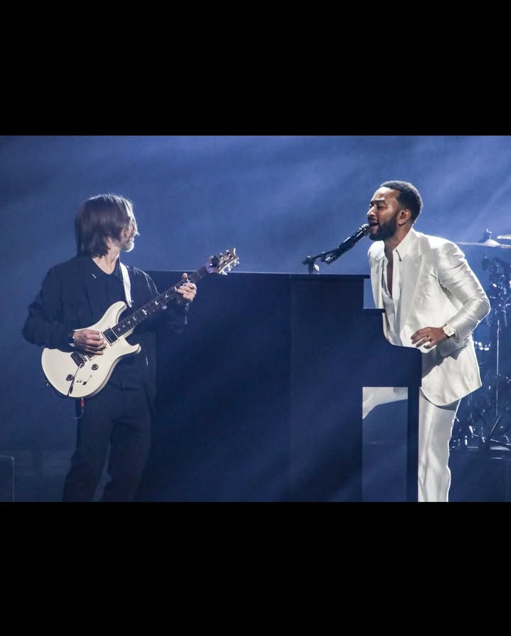 May be an image of suit, guitar, concert and text