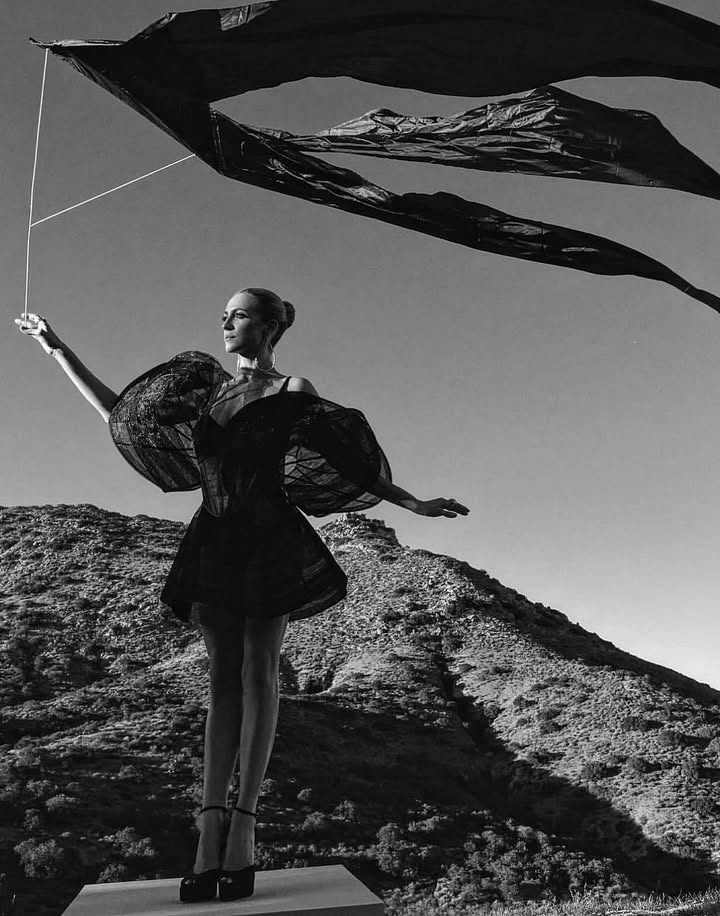 May be a black-and-white image of dancing, umbrella, parasol, parachute, kite and text