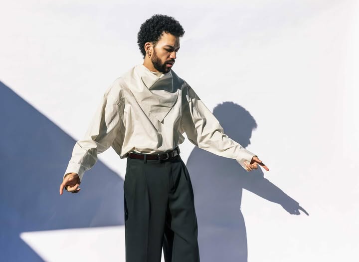 May be an image of overcoat, suit, turtleneck and text