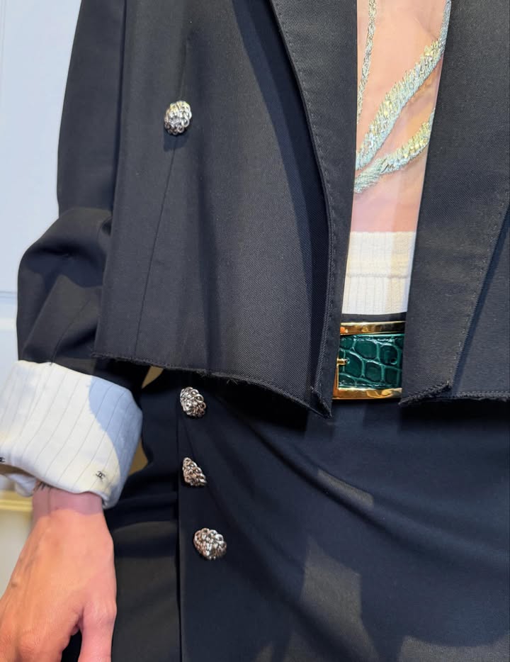 May be an image of suit, belt, blazer and text