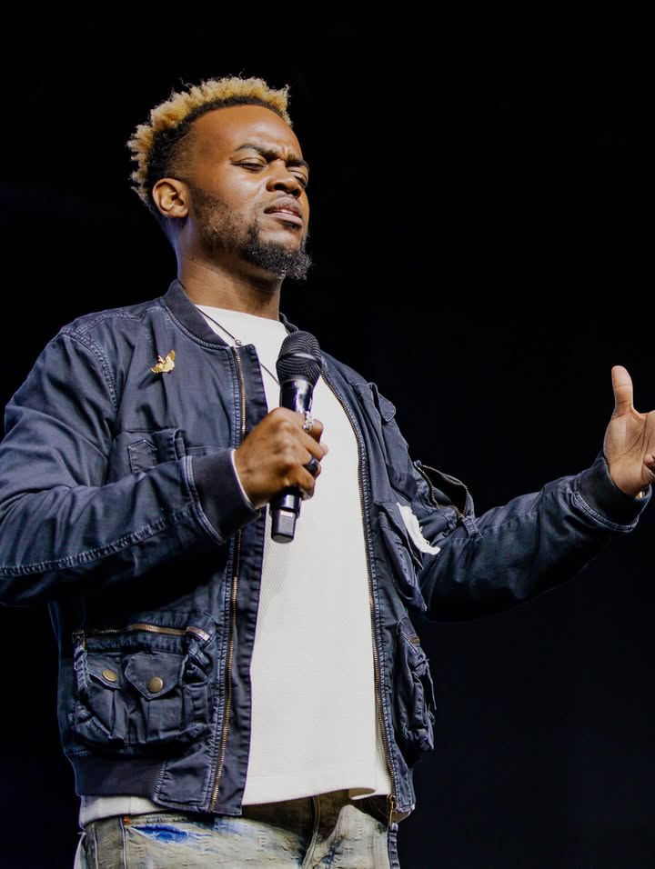 May be an image of one or more people, people standing, microphone, concert and text