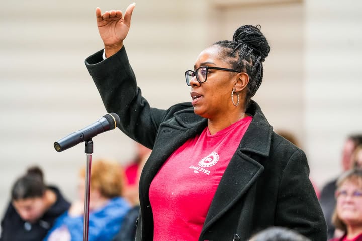 May be an image of one or more people, people standing, microphone and text