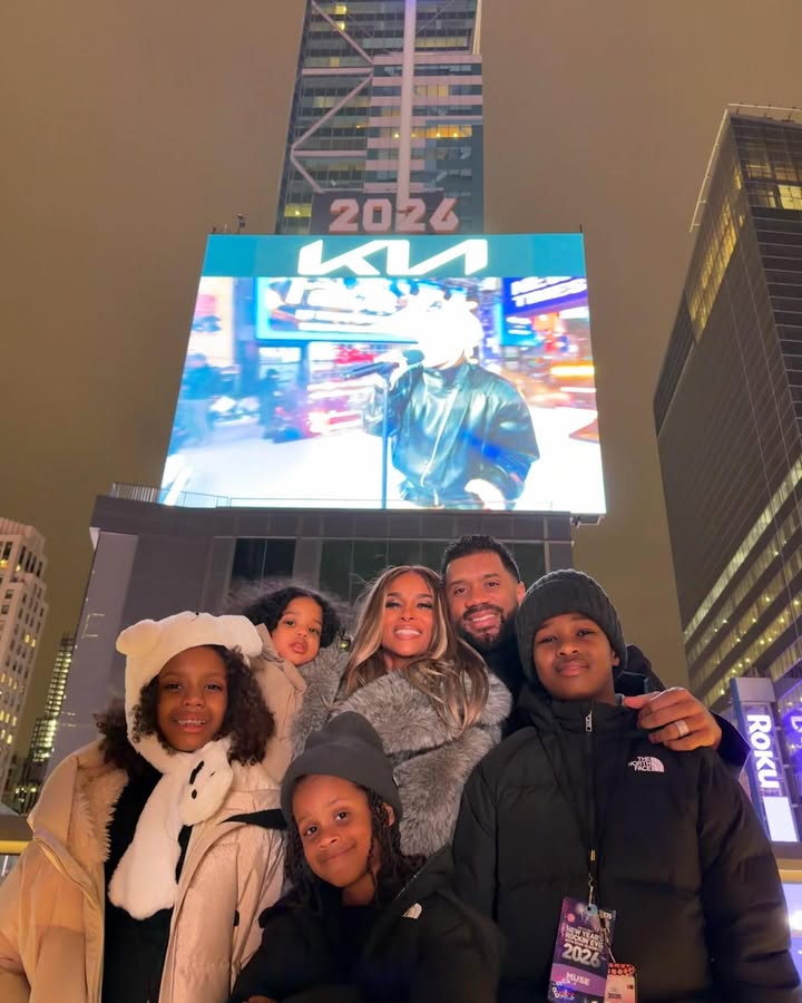 May be an image of one or more people, people standing, Times Square, night and text