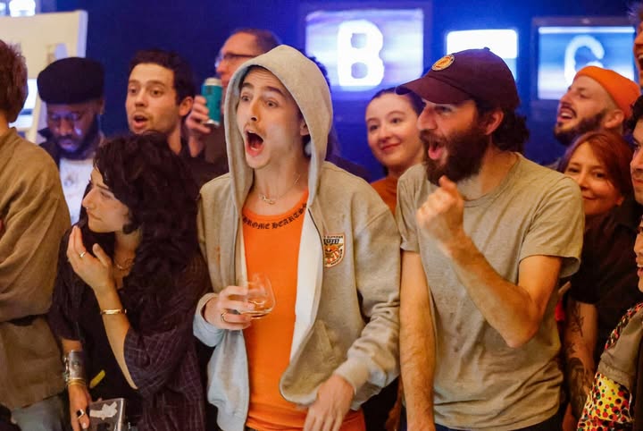 May be an image of one or more people, television, crowd and text