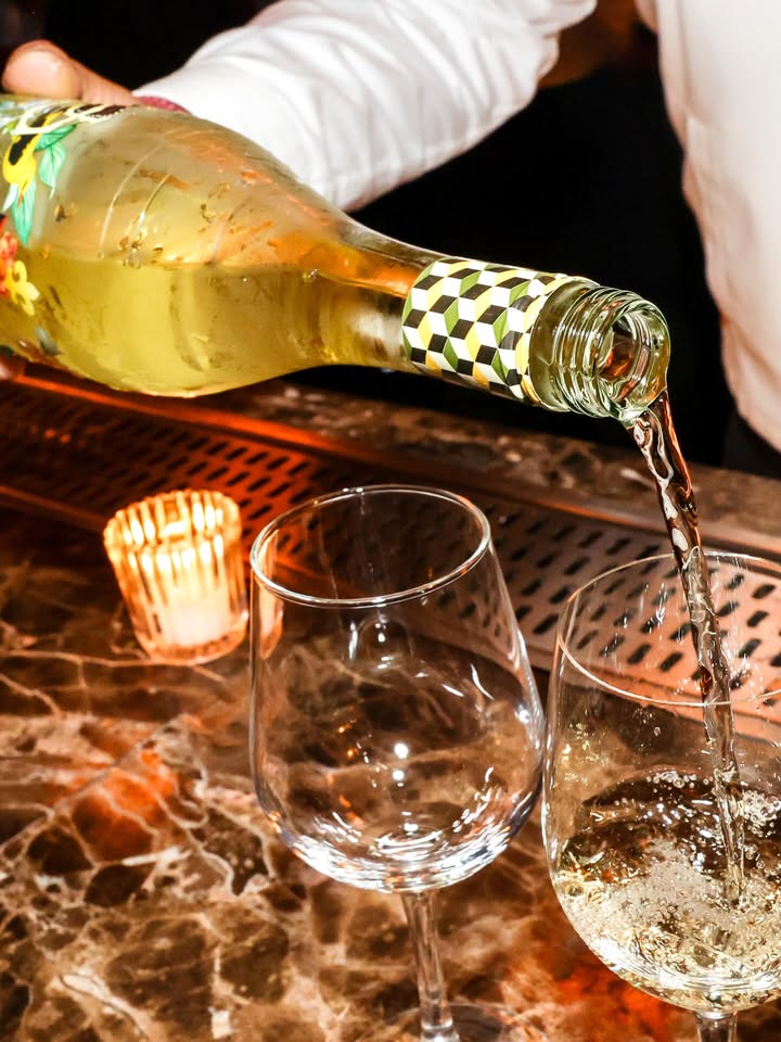 May be an image of champagne, wine glass, bottle and text