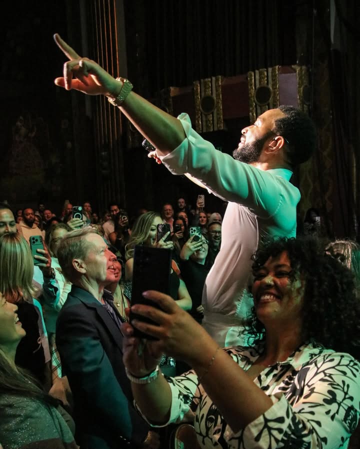 May be an image of dancing, standing, microphone, tambourine, crowd and text