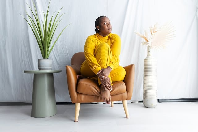 May be an image of one or more people, armchair and text