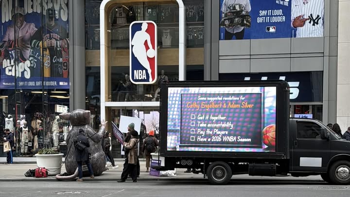 May be an image of basketball, standing, poster, scoreboard, truck, crowd and text that says 'BLTHETITE SAYI LOUD, GIFTI GIFTITLOUDER LOUDER ChPS BAGANA . SAYIT SAYITLOU TLOUO. GIFT LOUDER. NEAQIE = NBA T Same sungentadres resolntions for Cathy Engelbert& Adam Silver 0 Geti together Take accouT accountabithy Trabam Pay the Playera Have 2026 WNBA Semson Lide'