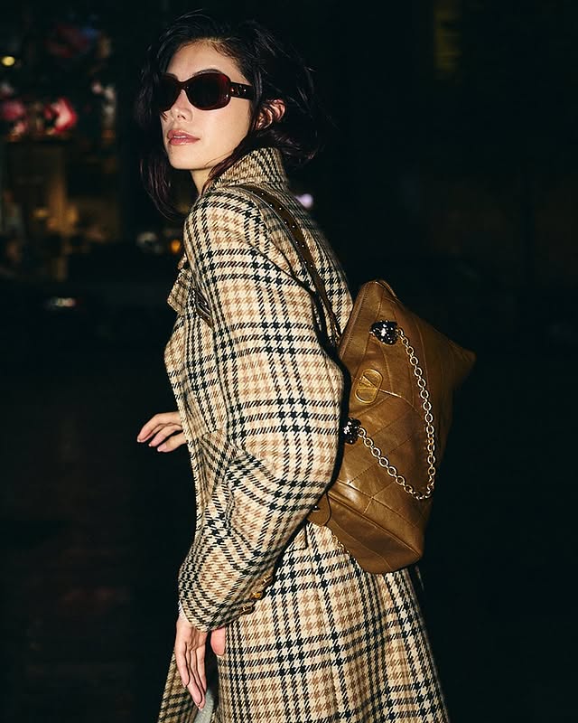 May be an image of duffle coat, eyewear, overcoat, purse and text