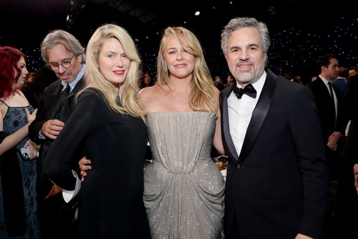 May be an image of one or more people, blonde hair, carpet, gown, dinner jacket and text