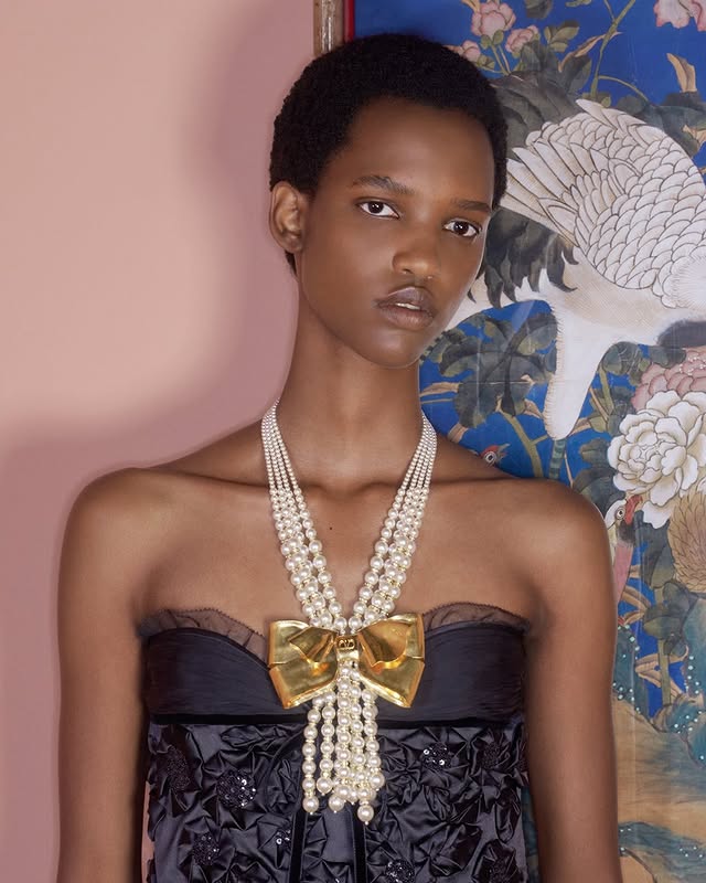 May be an image of one or more people, makeup, jewelry, neckwear and text