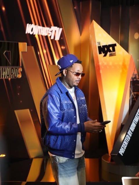 May be an image of one or more people, people standing, television, microphone, jacket and text