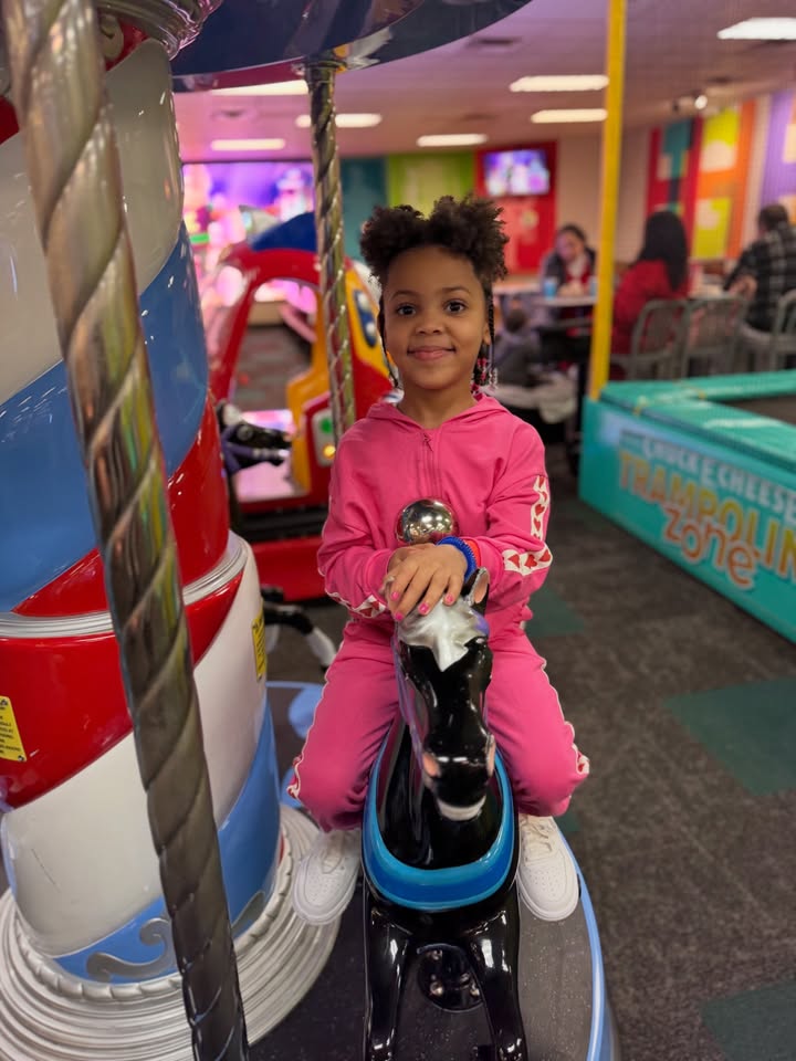 May be an image of child, smiling, pony, carousel and text