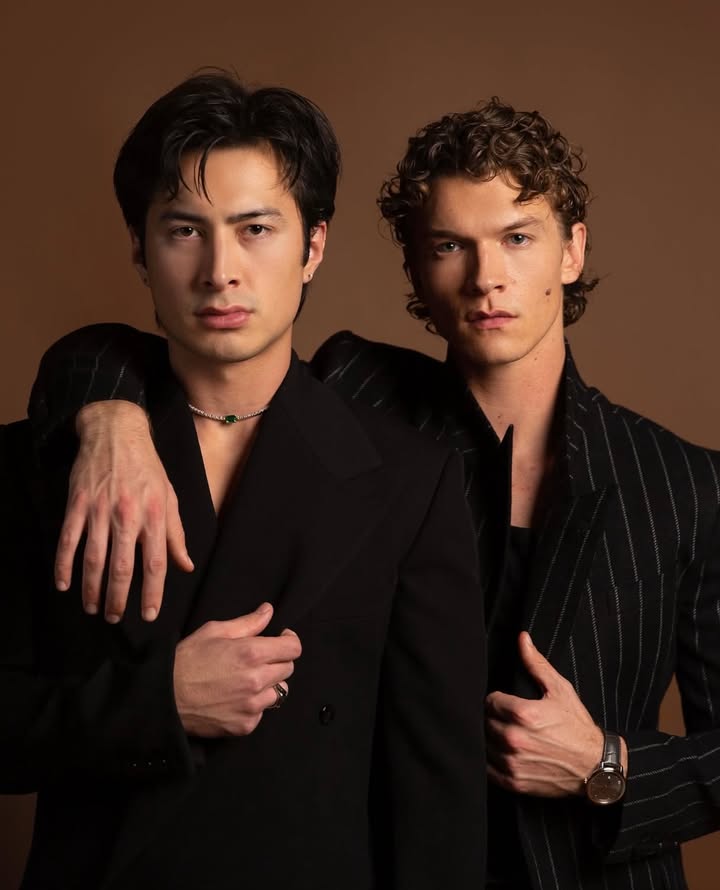 May be an image of one or more people, hair, makeup, suit, dinner jacket, bolo tie and text