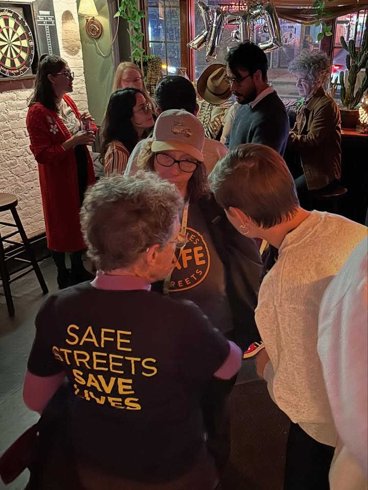 May be an image of standing, dartboard, crowd and night