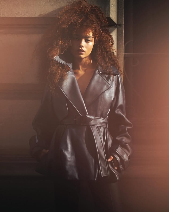 May be an image of one or more people, makeup, leather, overcoat, jacket, raincoat and text